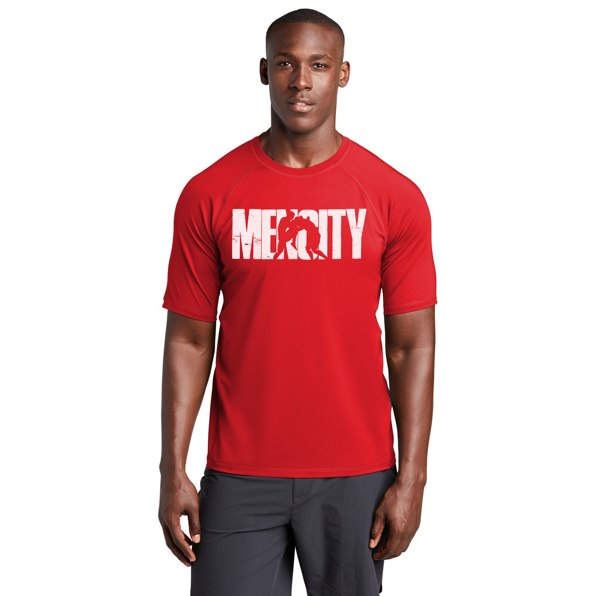 Man wearing the red Mencity Fight Camp rashguard tee with white MENCITY chest graphic, front view