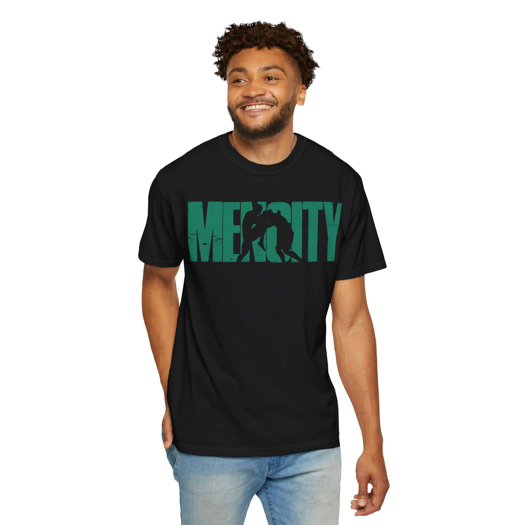 Smiling man wearing the black Mencity Fighter gym t-shirt with green MENCITY boxer wordmark, with jeans